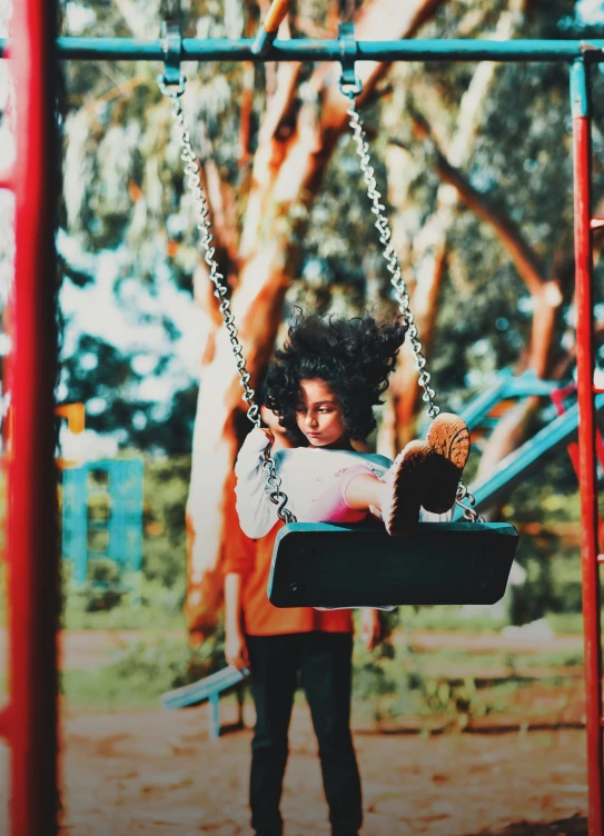 a little girl that is sitting on a swing, a picture, inspired by Gordon Parks, pexels contest winner, with instagram filters, ( ( dark skin ) ), colorful scene, square