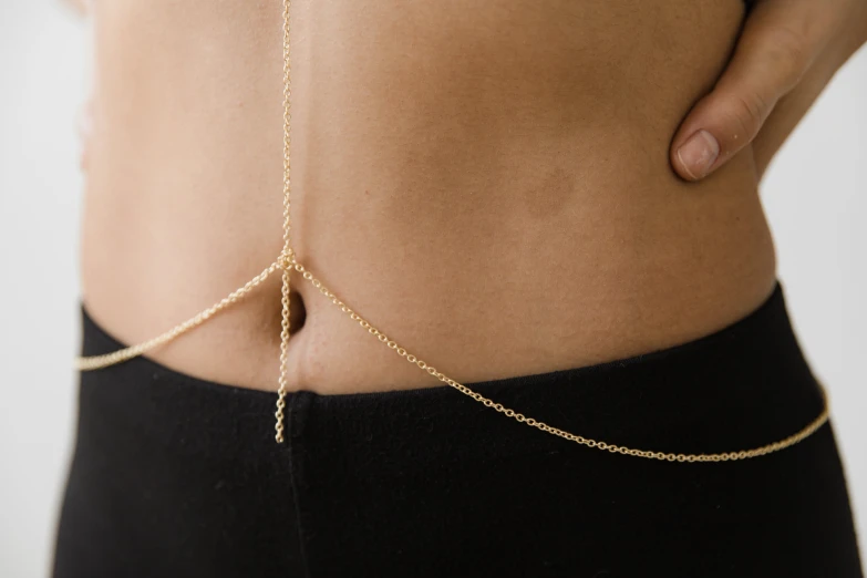 a woman with a chain around her waist, by Nina Hamnett, trending on pexels, minimalism, rib cage exposed, 14k gold wire, stick poke, hanging