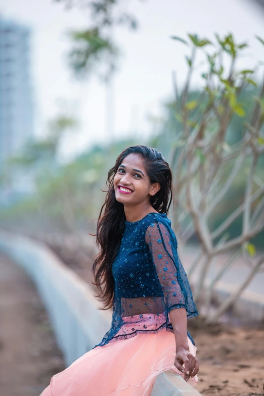 a woman sitting on top of a cement wall, by Max Dauthendey, pexels contest winner, smiling girl, headshot profile picture, wearing crop top, desi