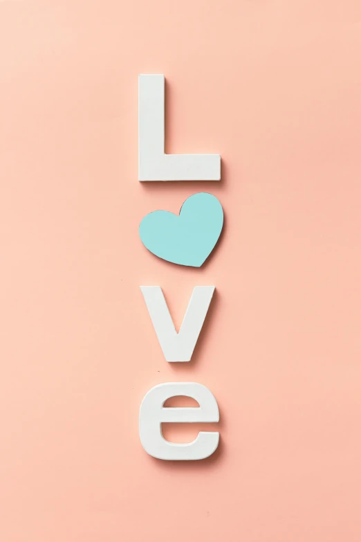 the word love with a blue heart on a pink background, poster art, trending on pexels, society 6, low detail, teal orange, cute photograph
