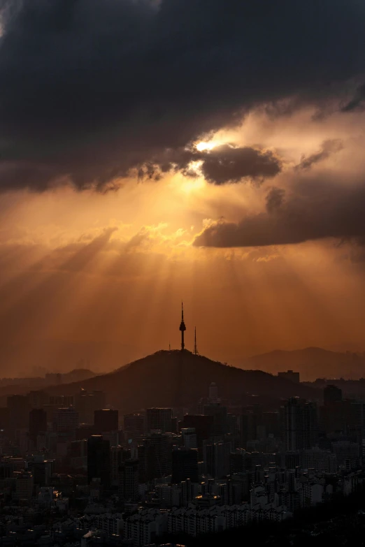 the sun shines through the clouds over a city, by Jang Seung-eop, pexels contest winner, fujifilm”