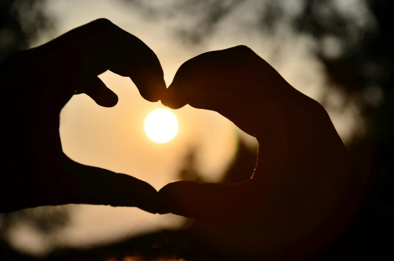 a person making a heart shape with their hands, by Matt Cavotta, pexels, suns, romantic lead, paul barson, ad image