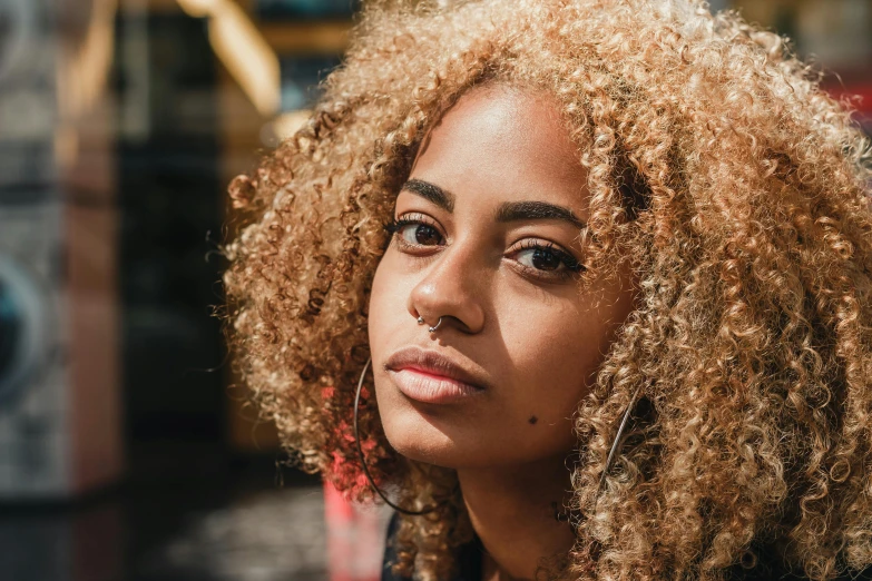 a close up of a person with curly hair, a character portrait, trending on pexels, short blonde afro, young women, prompt young woman, light-brown skin