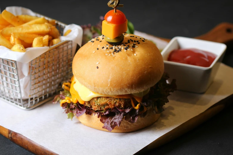 a hamburger sitting on top of a cutting board next to a basket of fries, a portrait, unsplash, malaysian, yellow, 🦩🪐🐞👩🏻🦳, fine dining