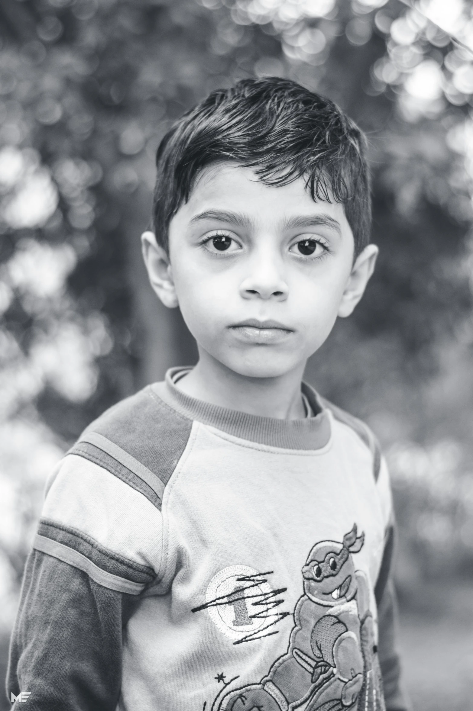 a black and white photo of a young boy, by Riza Abbasi, color photograph portrait 4k, center of picture, low quality photograph, 8 5 mm photograph