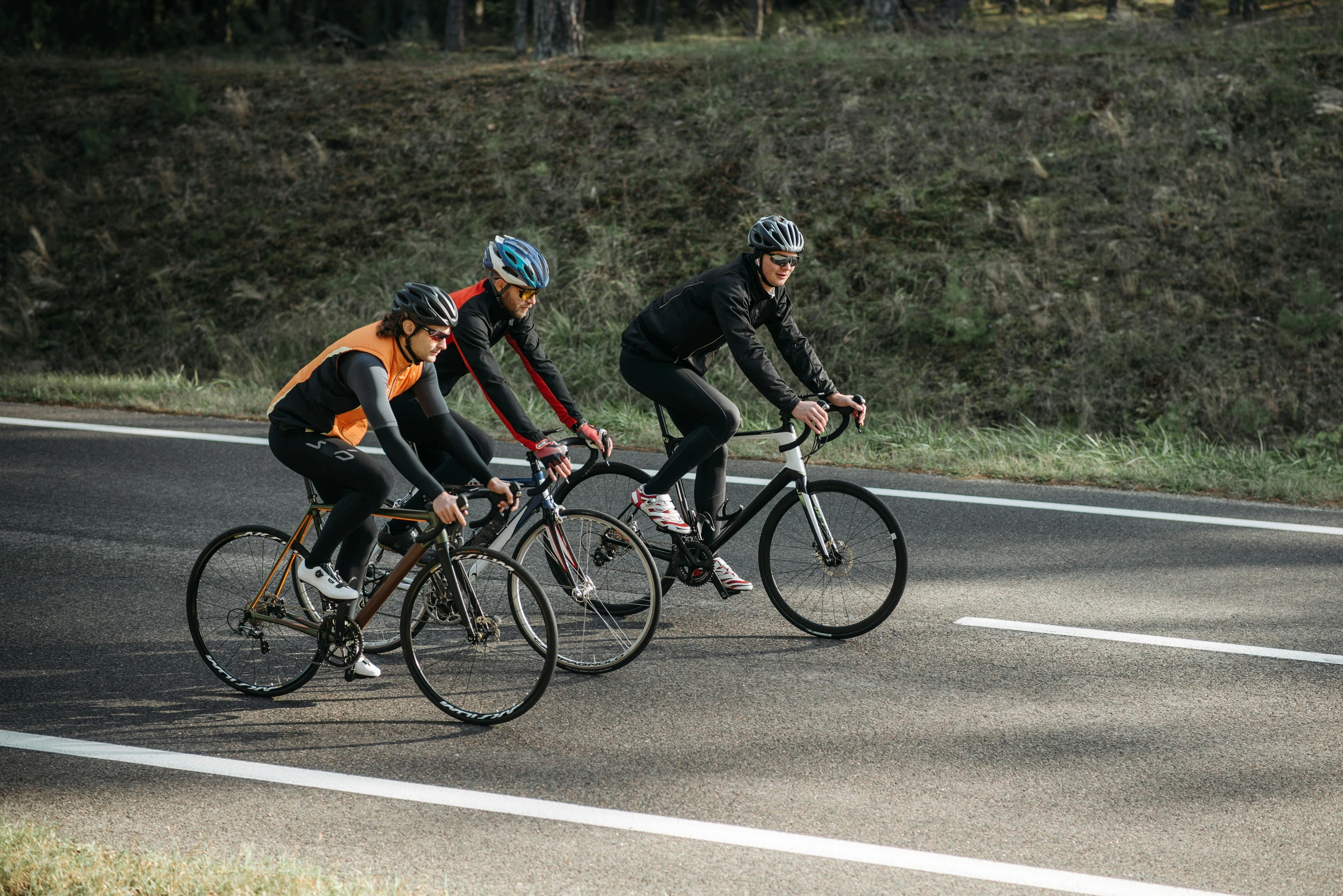 a couple of men riding bikes down a road, three people running a marathon, neoprene, profile image, paved roads