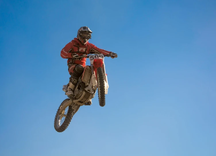 a man flying through the air while riding a dirt bike, pexels contest winner, figuration libre, fine detail, brown, mechanic, profile picture