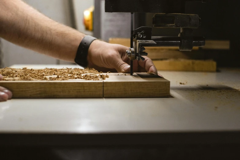 a person cutting a piece of wood with a machine, by Matthias Stom, pexels contest winner, arts and crafts movement, high quality print, brown, action shot, plating