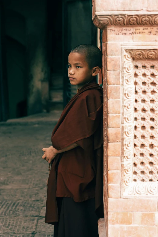 a young monk standing in front of a building, inspired by Steve McCurry, unsplash contest winner, full frame image, thoughtful ), ( ( theatrical ) ), brown robes