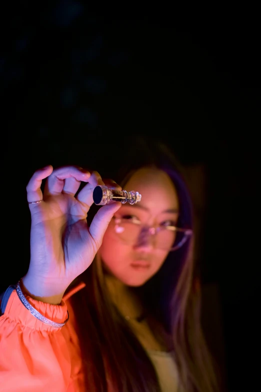 a woman holding a pair of scissors in front of her face, a picture, inspired by Zhu Da, pexels, visual art, holding a small vape, wide angle lens glow in the dark, nug pic, full body in shot