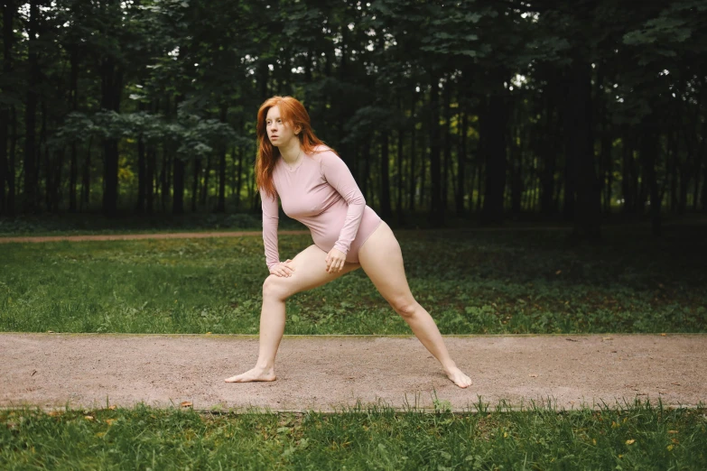 a woman that is standing in the grass, inspired by Elizabeth Polunin, pexels contest winner, wearing leotard, smooth pink skin, at a park, ( redhead