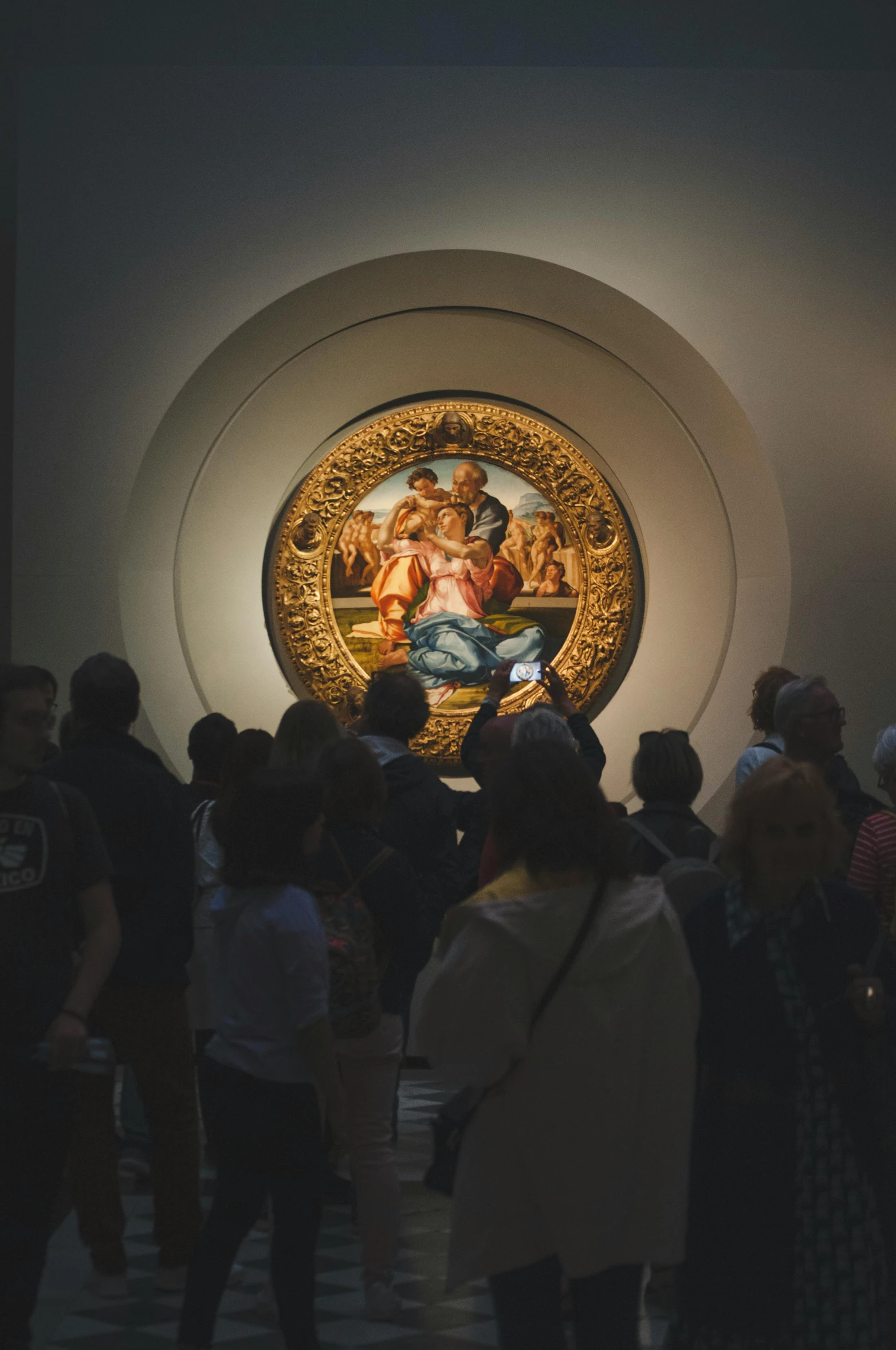 a group of people standing in front of a painting, by Andrea del Verrocchio, trending on unsplash, in a circle, museum light, gilded relief, high quality image