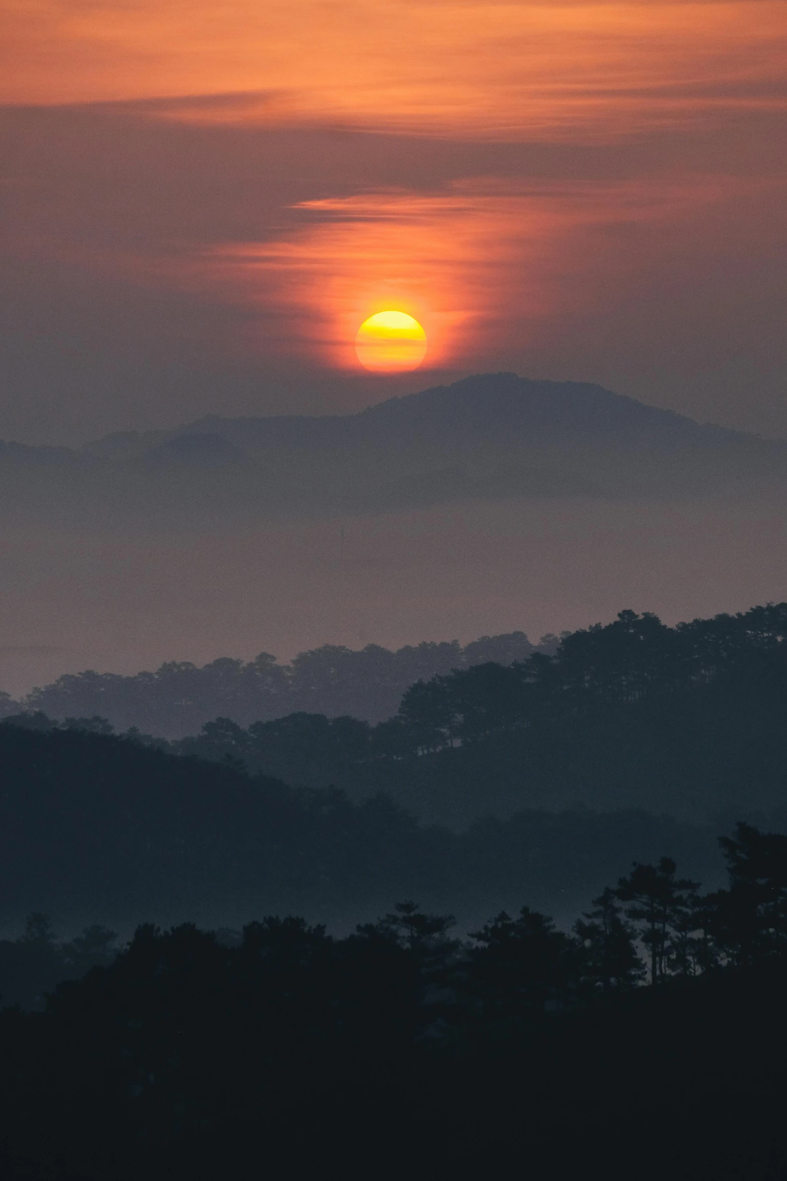 the sun is setting over the mountains in the distance, by Ian Fairweather, sumatraism, alabama, misty, big red sun, today\'s featured photograph 4k