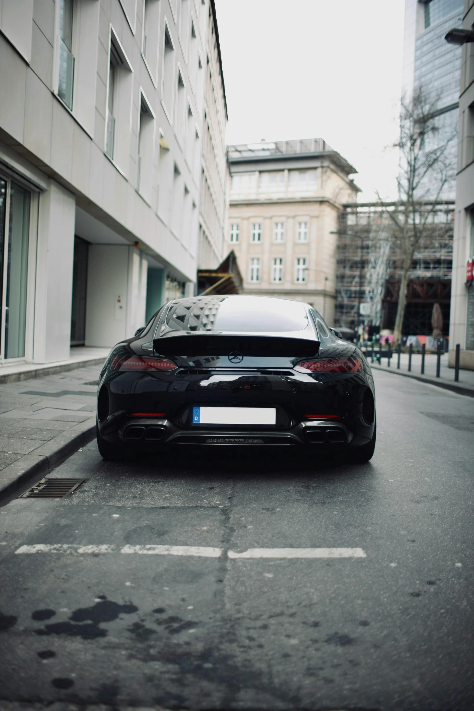 a black sports car parked on the side of a street, pexels contest winner, realism, back camera, germany. wide shot, tight bun, 🚿🗝📝