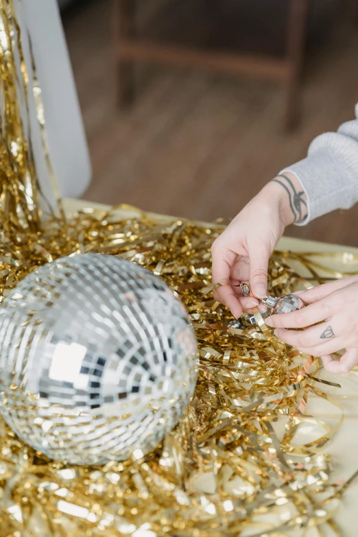 a woman places a disco ball on a table, by Julia Pishtar, ornament crown, filling the frame, silver and gold, seasonal