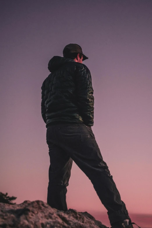 a man standing on top of a mountain at sunset, an album cover, trending on pexels, aestheticism, techwear clothes, plain background, black clothing, view(full body + zoomed out)