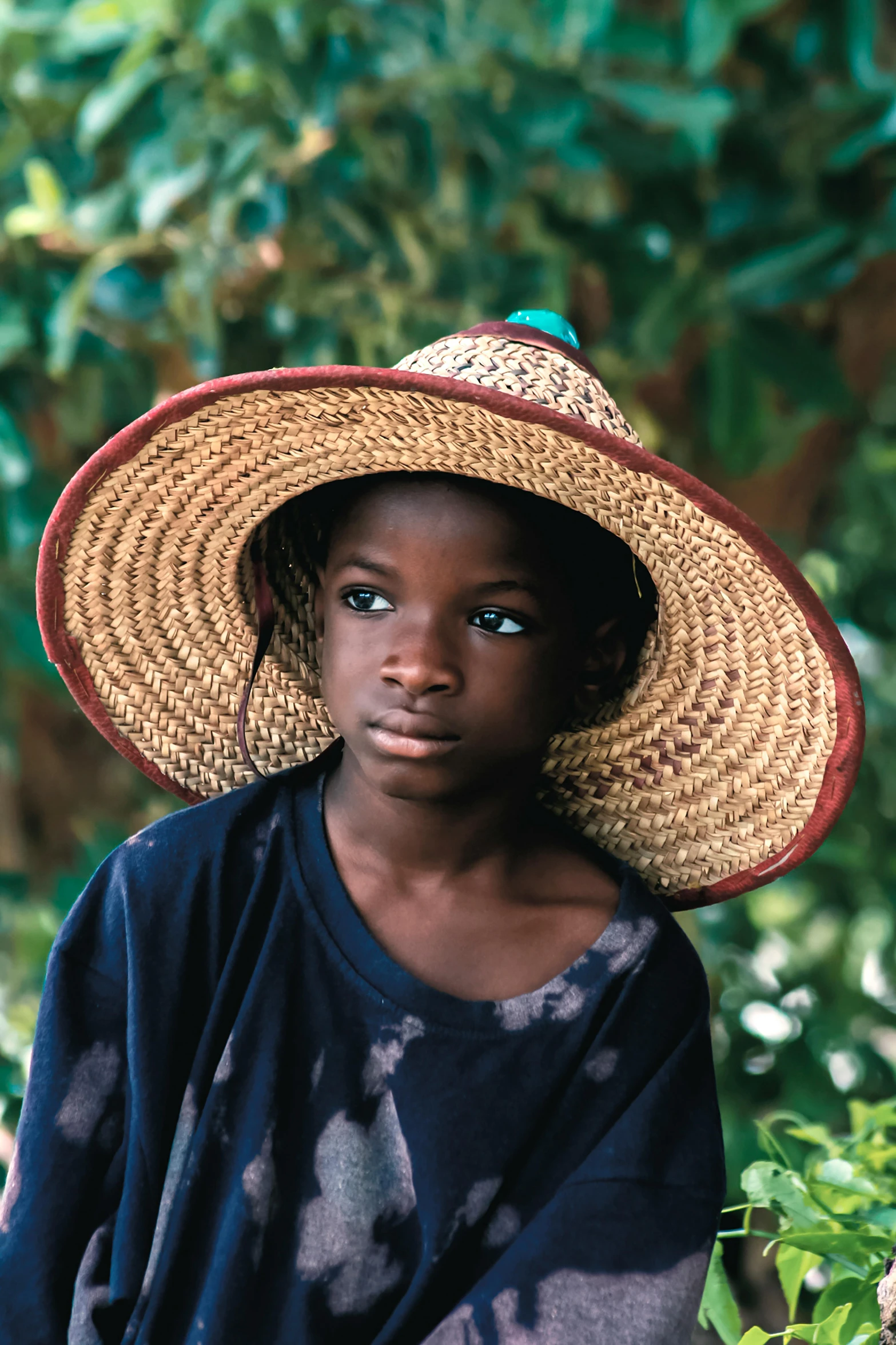 a close up of a person wearing a hat, by Chinwe Chukwuogo-Roy, pexels contest winner, renaissance, portrait young girl, lush surroundings, looking serious, on a village