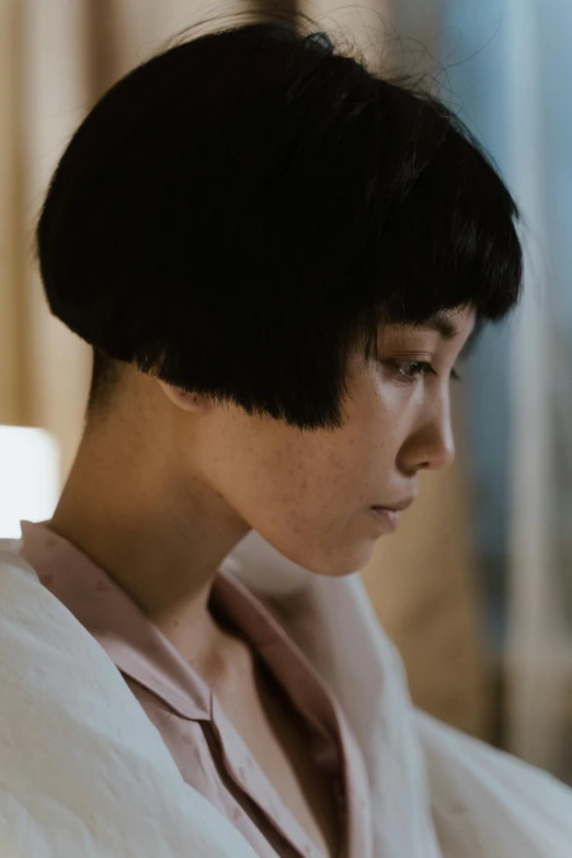 a woman in a bathrobe using a cell phone, an album cover, inspired by Itō Shinsui, pexels contest winner, mingei, 1 9 3 0 s haircut, close up shot from the side, kiko mizuhara, award winning. cinematic