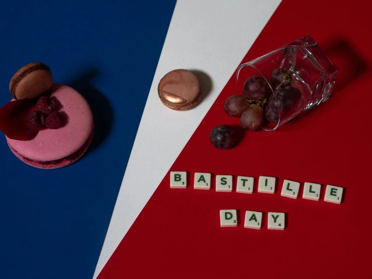 a couple of macarons sitting on top of a red, white and blue table, an album cover, inspired by Jacques-Louis David, pexels, de stijl, x - day, brutalism style, day of the tentacle, a wooden