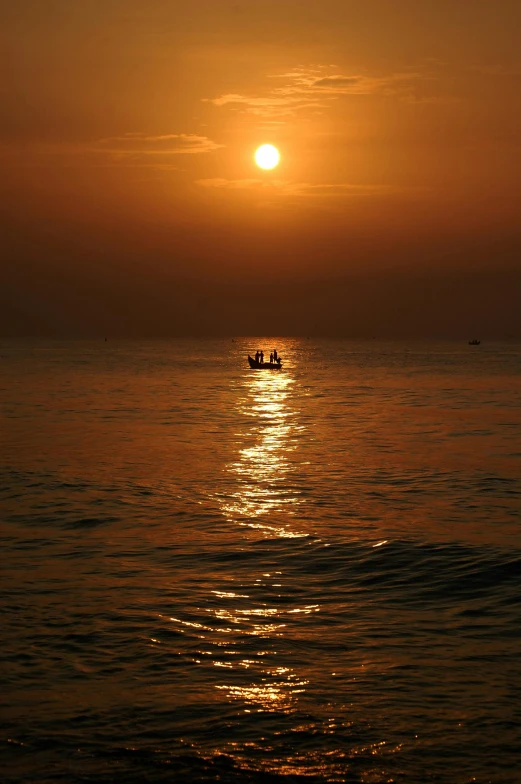 a couple of boats floating on top of a body of water, pexels contest winner, romanticism, orange sun set, varadero beach, rippling, oman