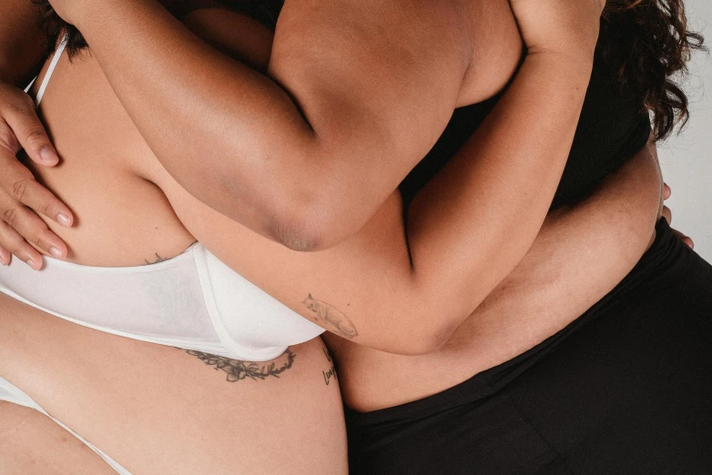 a man and a woman hugging each other, a tattoo, by Jessie Alexandra Dick, trending on pexels, massurrealism, underwear ad, product introduction photo, bottom body close up, diverse