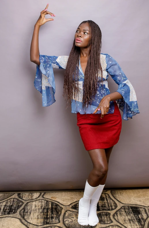 a woman in a red skirt posing for a picture, an album cover, inspired by Chinwe Chukwuogo-Roy, shutterstock contest winner, mini jeans skirt, hipple and boho fashion 1970s, studio shooting, wearing a blouse