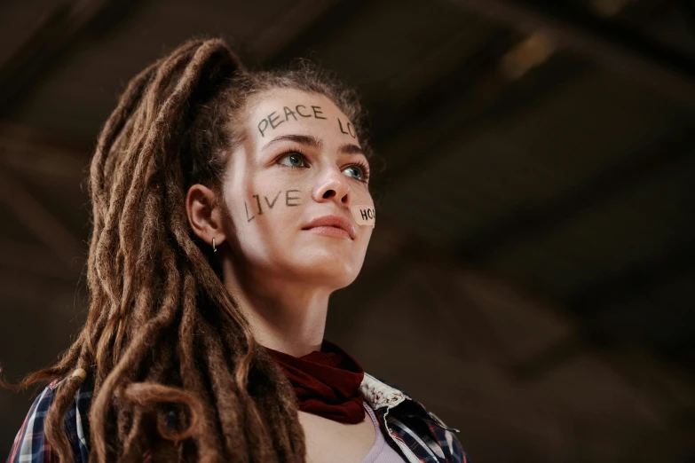 a woman with dreadlocks and writing on her face, a portrait, trending on pexels, antipodeans, love peace and unity, avatar image, girl with brown hair, professional master piece