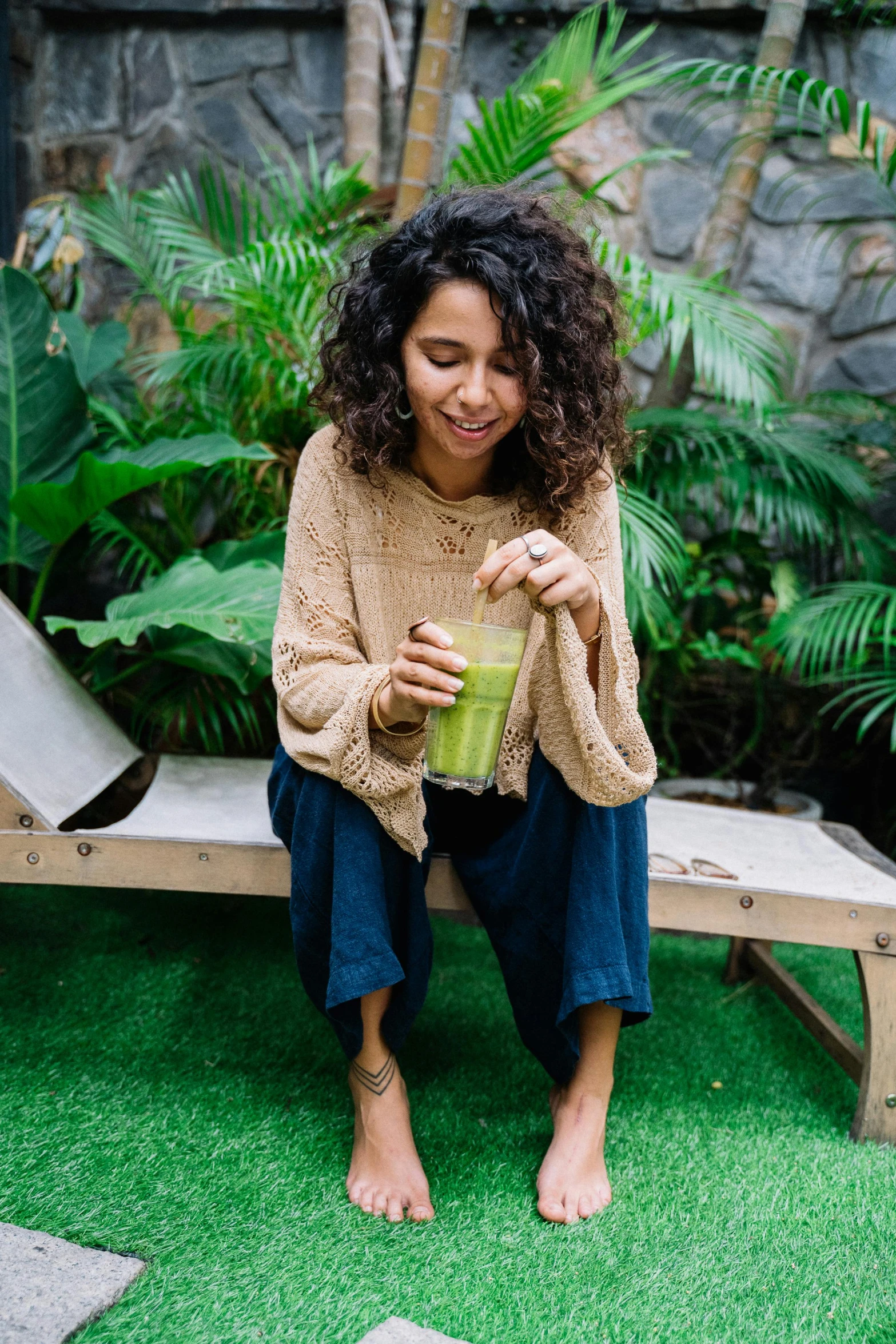 a woman sitting on a bench with a drink in her hand, moringa juice, justina blakeney, alanis guillen, curls