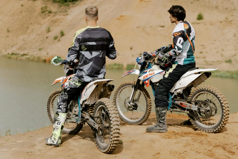 a couple of men standing next to each other on dirt bikes, a picture, unsplash, figuration libre, off - white collection, zoomed in, sport clothing, hd footage