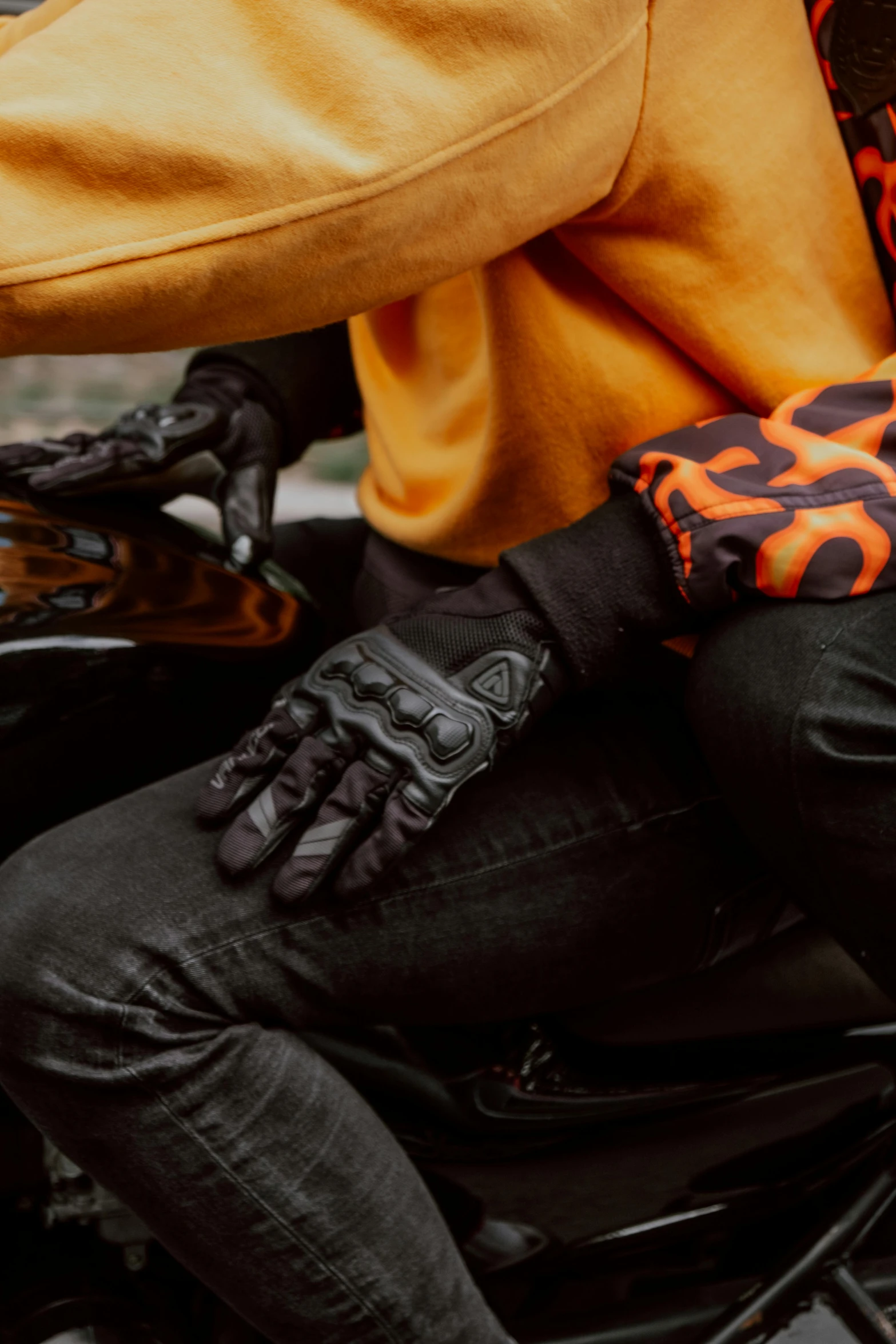 a man riding on the back of a motorcycle, inspired by Cam Sykes, trending on pexels, renaissance, tiger paws as gloves, orange and black tones, black textured, leather cuffs around wrists