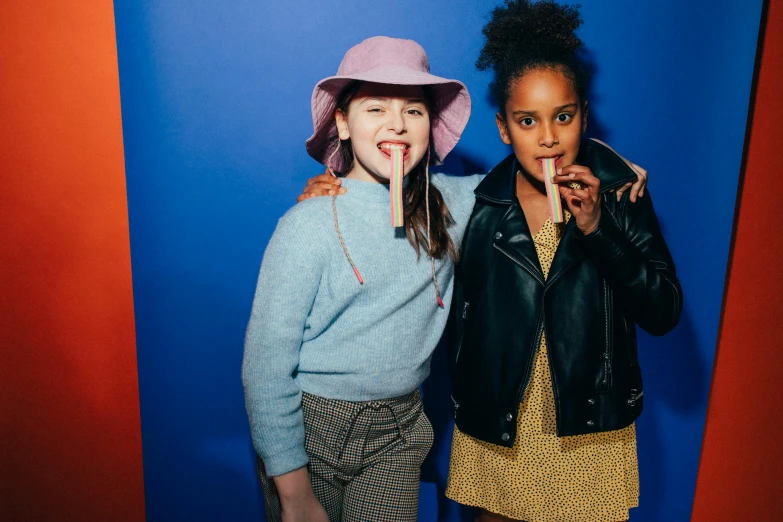 a couple of young girls standing next to each other, by Nathalie Rattner, trending on unsplash, photo booth, with a straw, softplay, wearing a beret