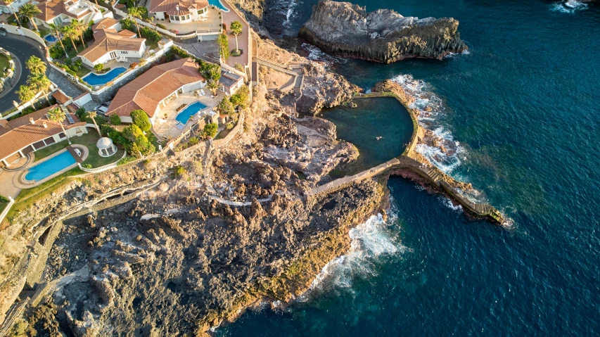 a house sitting on top of a cliff next to the ocean, by Simon Marmion, pexels contest winner, les nabis, aerial view, pools of water, thumbnail, epic 3 d omolu