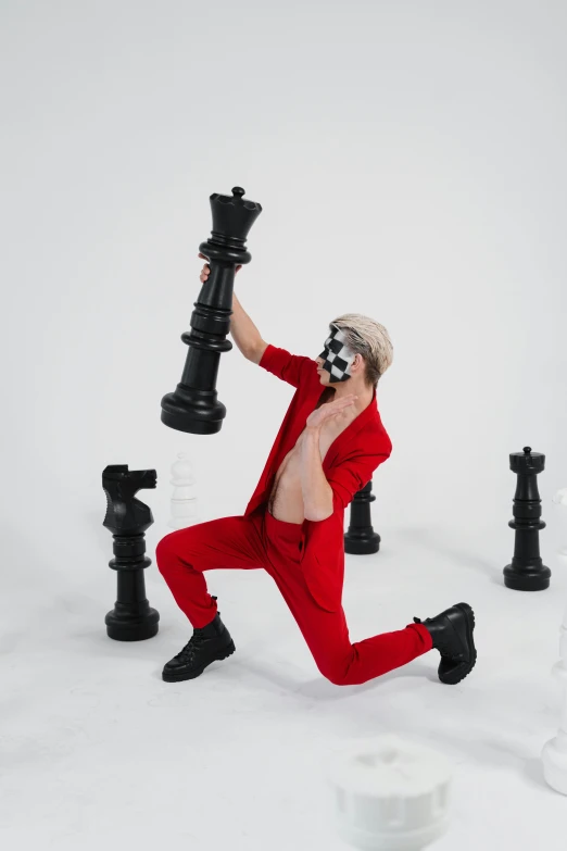 a man in a red suit playing a game of chess, an album cover, inspired by Jens Ferdinand Willumsen, pexels contest winner, zentai suit, xqc, full body photoshoot, cutecore clowncore