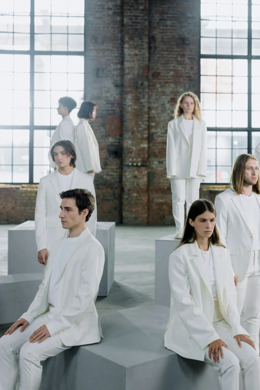 a group of people dressed in white sitting on cubes, an album cover, inspired by Vanessa Beecroft, trending on unsplash, in a flowing white tailcoat, official store photo, looking away, nordic folk
