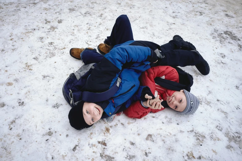 a couple of kids laying on top of each other in the snow, inspired by Jan Rustem, martin parr, 1999 photograph, colour photograph, boys