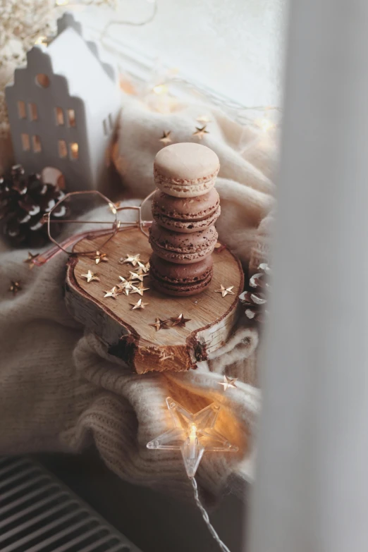 a stack of cookies sitting on top of a table, a picture, by Emma Andijewska, pexels contest winner, romanticism, emitting light ornaments, stars on top of the crown, miniature product photo, cozy vibe
