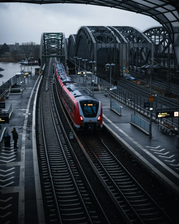 a train traveling down train tracks next to a bridge, pexels contest winner, german romanticism, busy city, thumbnail, low quality photo, lgbtq