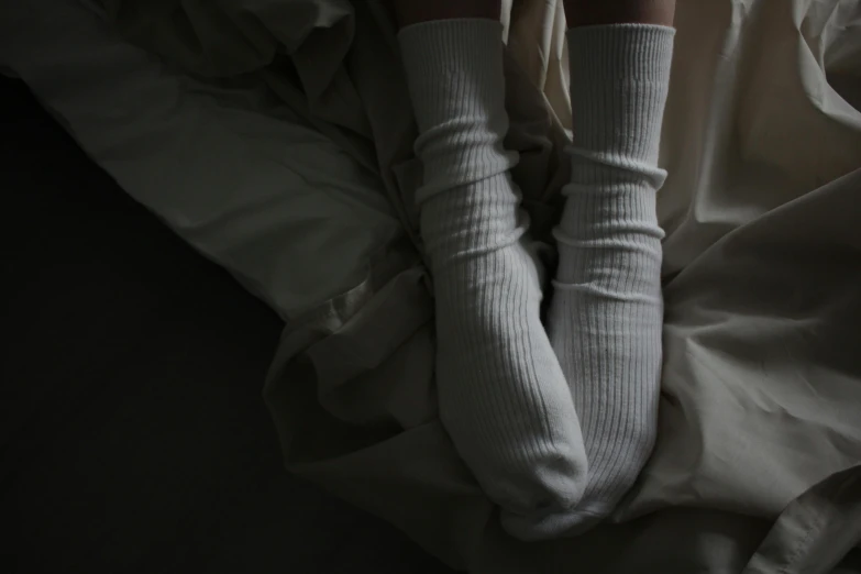 a person laying in bed wearing white socks, inspired by Elsa Bleda, renaissance, standing in a dark, unnerving anxiety, faceless people dark, leg high
