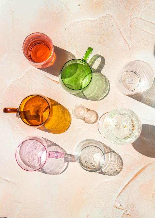 a group of glasses sitting on top of a table, a still life, trending on unsplash, process art, midsommar color theme, 6 colors, glossy surface, pink white and green