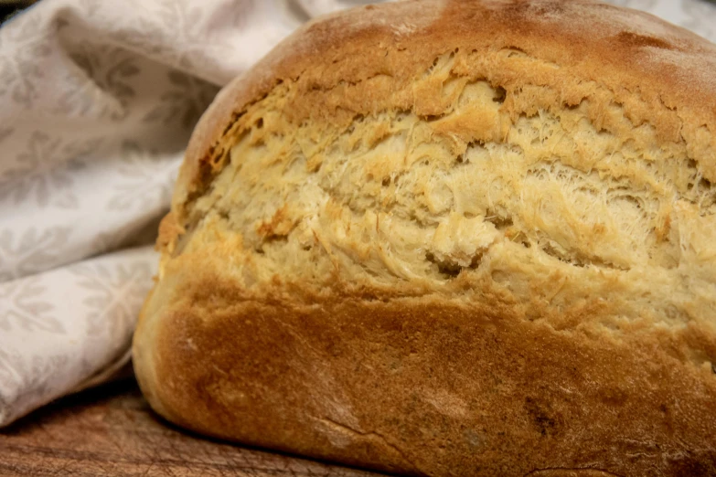 a loaf of bread sitting on top of a wooden cutting board, renaissance, fan favorite, up close image, taken with sony alpha 9, portrait image