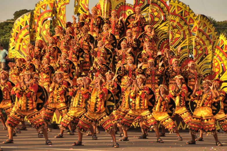 a group of people that are standing in the street, a digital rendering, by Kogan Gengei, flickr, dau-al-set, orange and yellow costume, philippines, black and yellow and red scheme, gorgeous and huge head ornaments