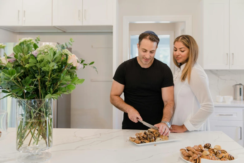 a man and woman standing in a kitchen preparing food, manuka, profile image, extra crisp image, on a white table