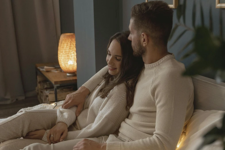 a man and a woman sitting on a bed, cosy vibes, sitting in a lounge, warm ambient lighting, instagram post