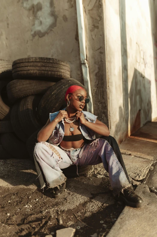 a woman sitting on the ground talking on a cell phone, an album cover, trending on pexels, afrofuturism, wearing a crop top, cinematic outfit photo, construction, badass pose