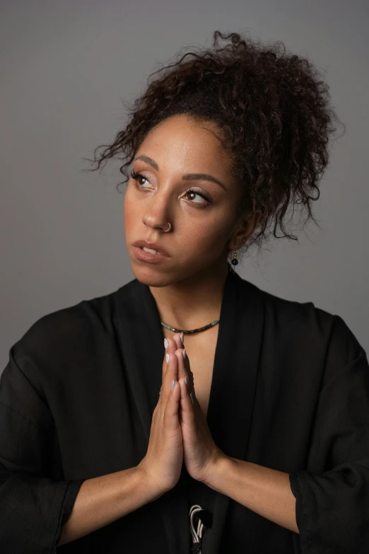 a woman with her hands folded in prayer, an album cover, inspired by Afewerk Tekle, unsplash, renaissance, acting headshot, vanessa morgan, casual pose, oona chaplin