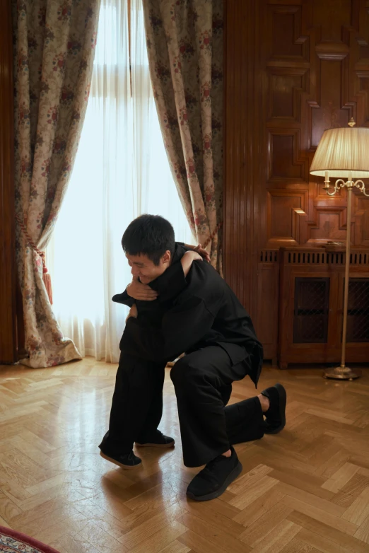 a man kneeling on the floor in a living room, by Marina Abramović, instagram, xi jinping, in spain, hugging his knees, hijikata toushirou of gintama