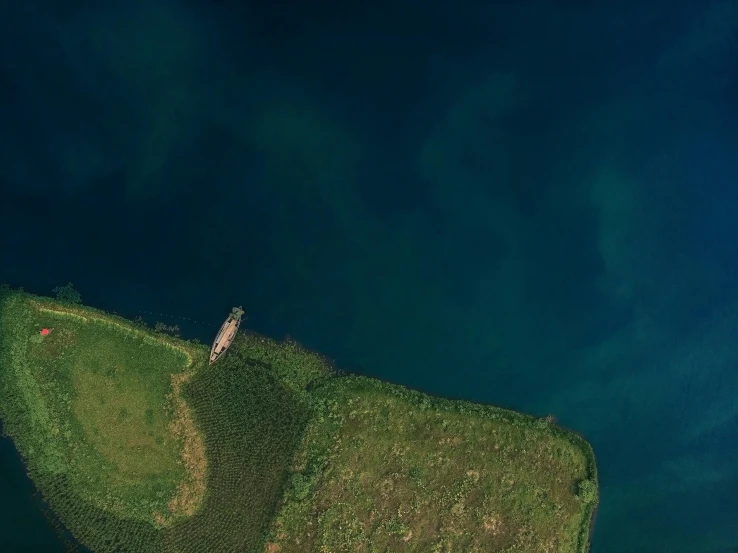 an aerial view of a small island in the middle of the ocean, by Attila Meszlenyi, pexels contest winner, land art, green and blue, sunken ship, bucklebury ferry, panoramic shot