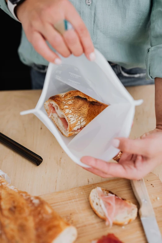 a close up of a person putting food in a bag, by Daniel Seghers, silicone cover, square, lunchmeat, no cropping