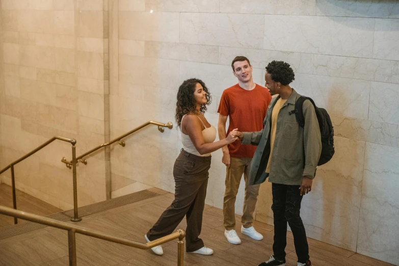 a group of people standing next to each other, pexels contest winner, happening, npc talking, inside the building, promo image, three