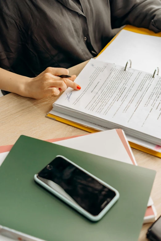 a woman sitting at a table with a book and cell phone, pexels contest winner, academic art, holding a clipboard, formulas, official documentation, stacked image